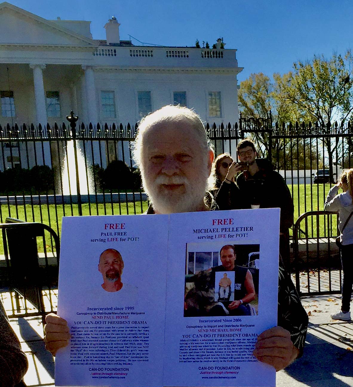 man standing outside the whitehouse holding Free Paul Free sign
